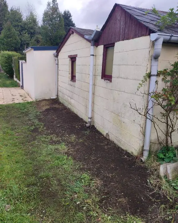 Pied de mur dégagé le long des descentes de gouttière